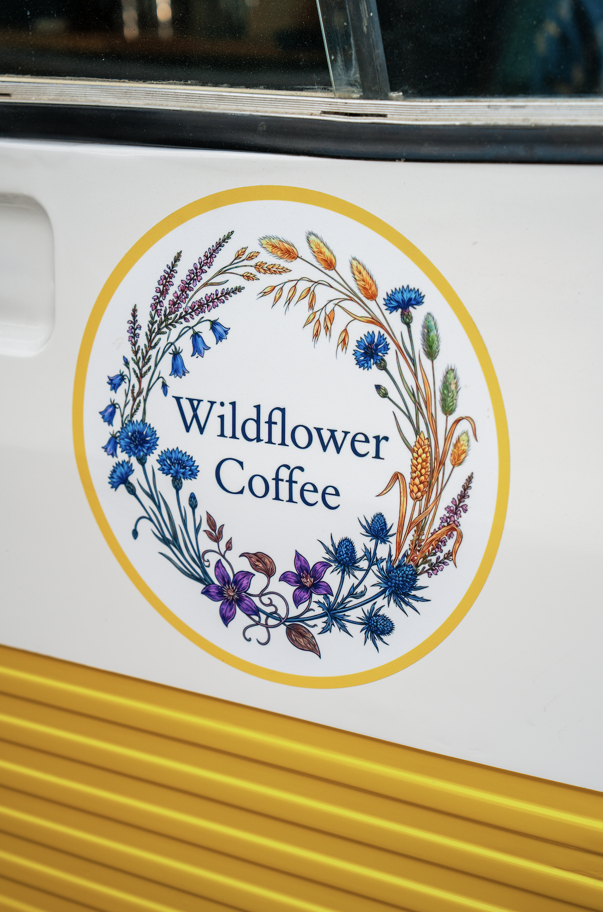 The Wildflower Coffee wildflower logo on the side of the van